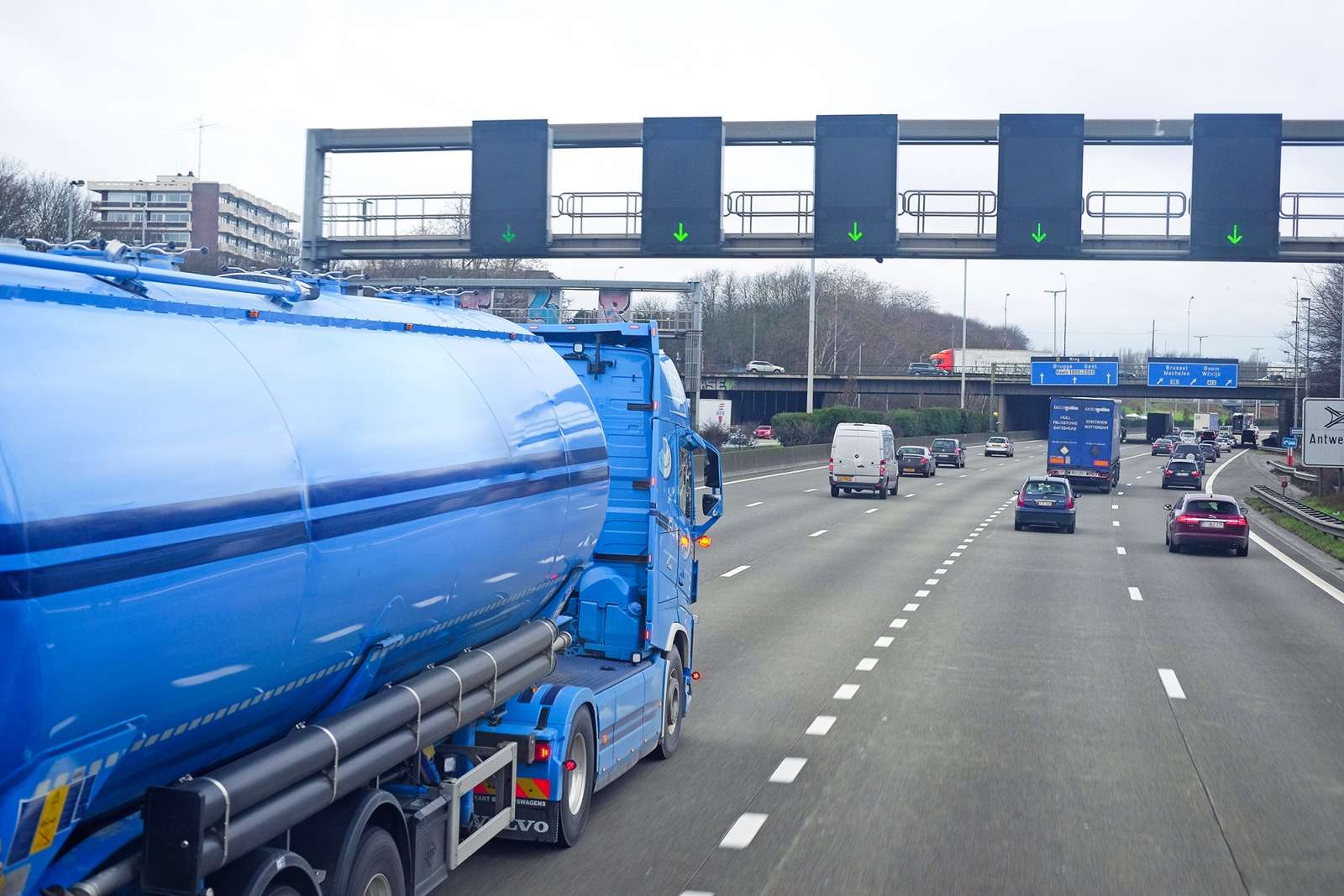 View from a truck cabin on a multi-lane highway with freight vehicles ahead